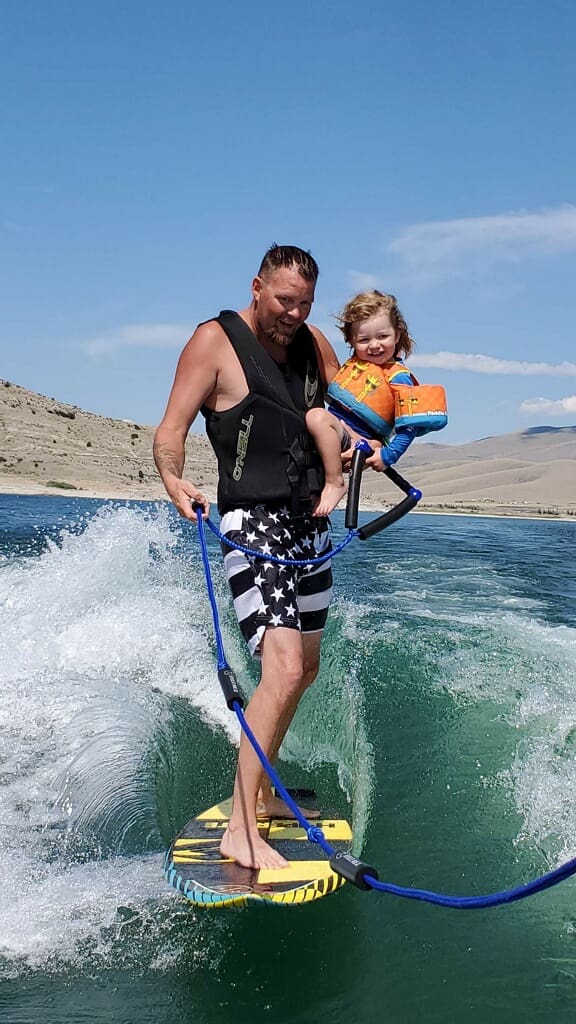 A man and child are water skiing on the lake.