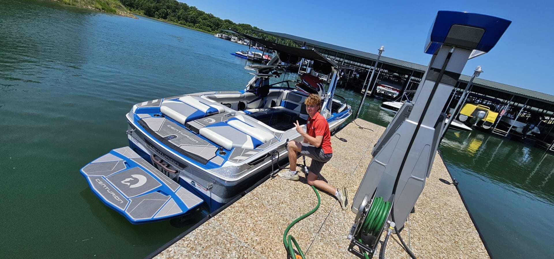 A man is washing his boat on the dock.