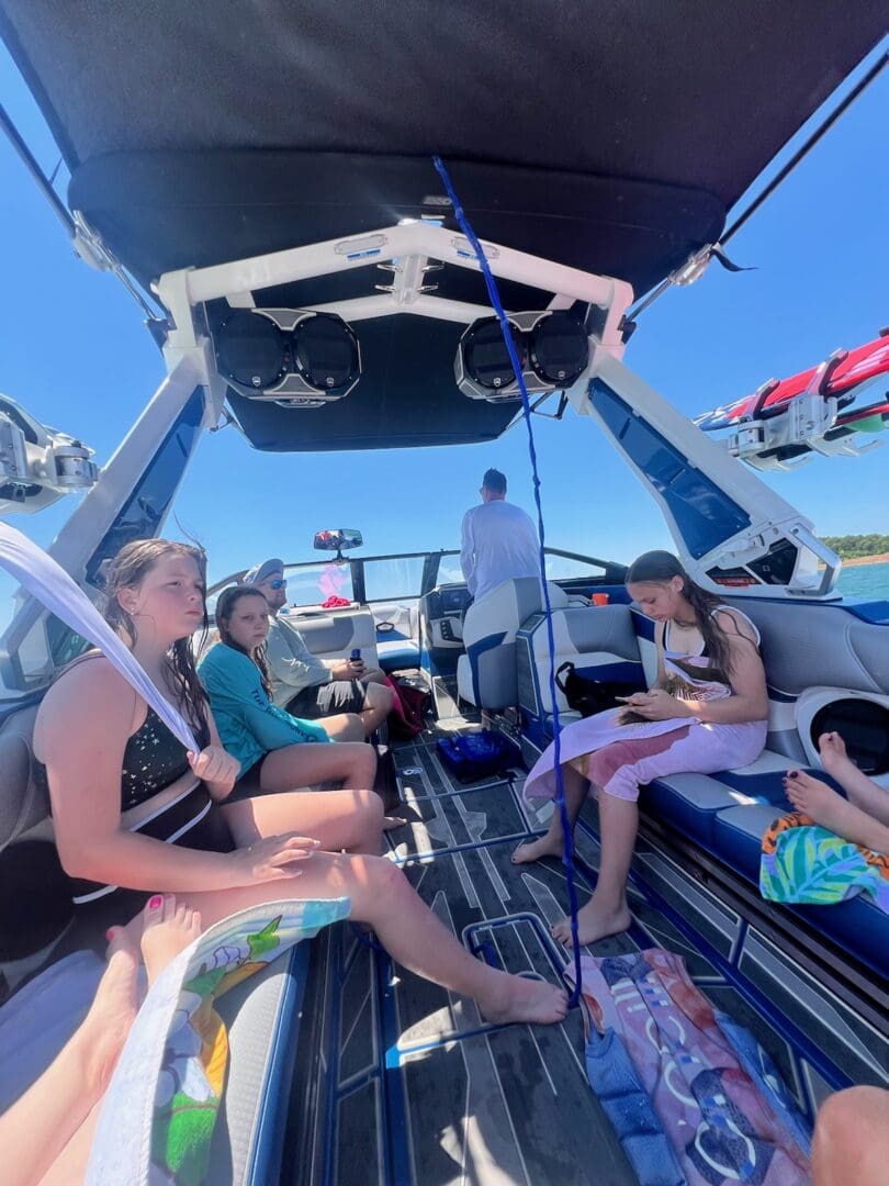 A group of people sitting on the back of a boat.