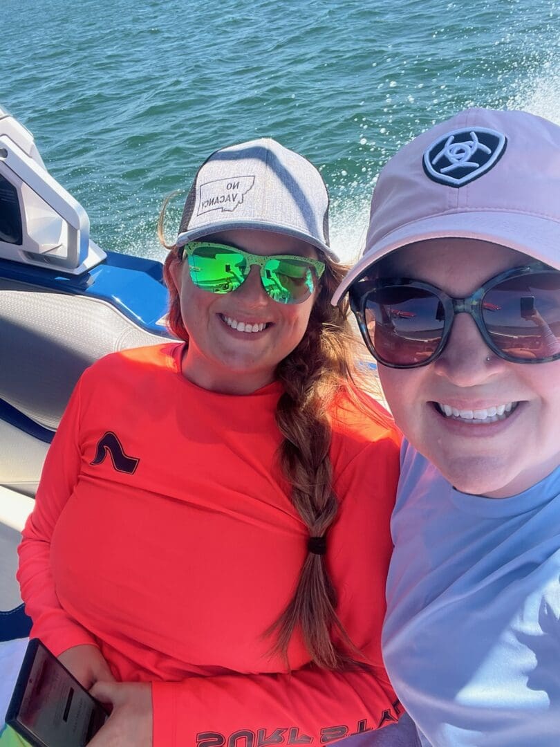 Two women are on a boat in the water.